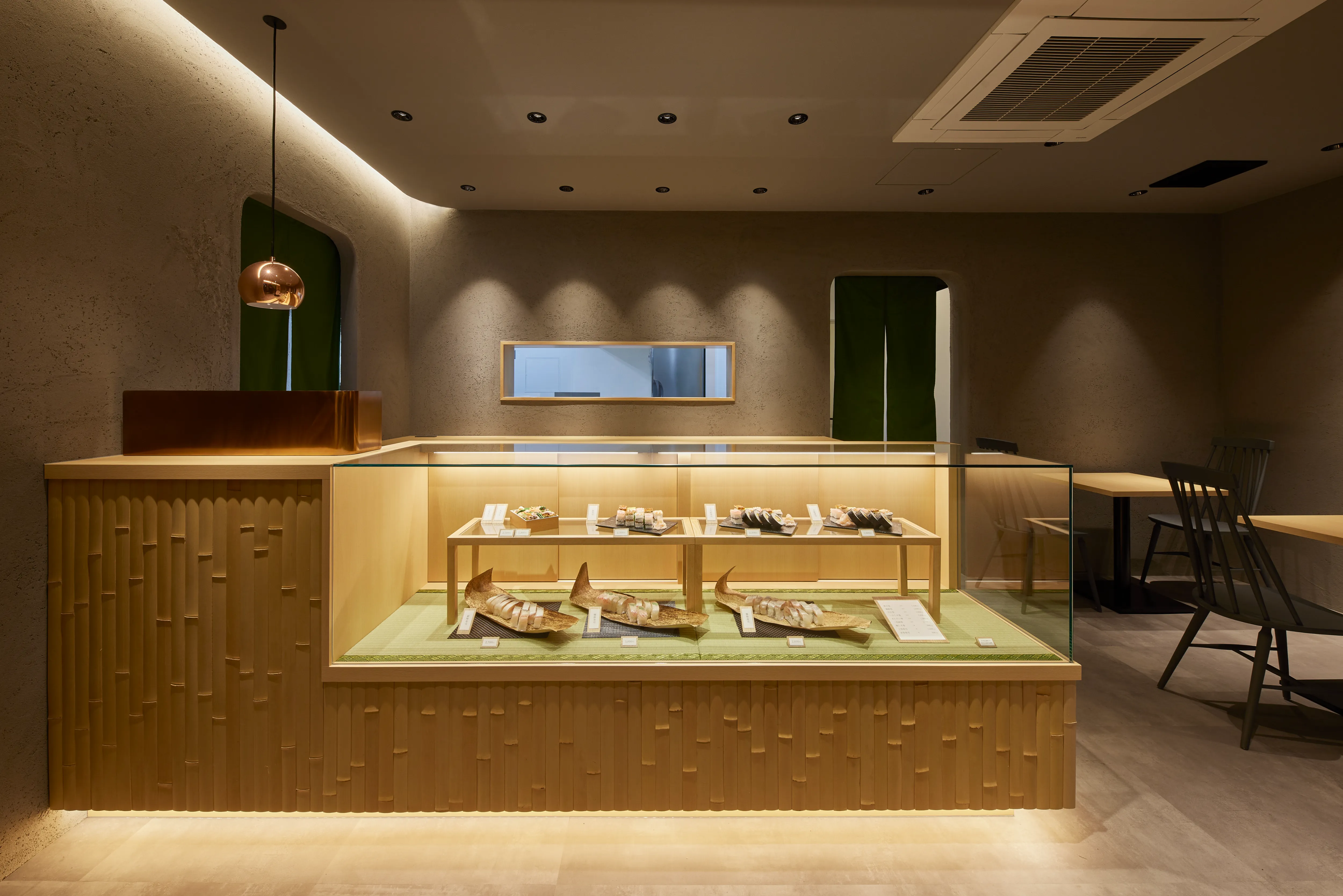 竹装飾が施された寿司店のショーケースカウンター